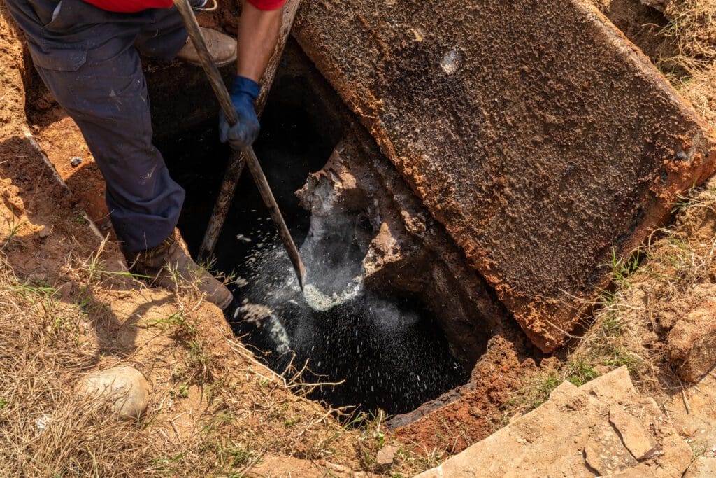 Breaking up an aged-concrete wastewater outlet in an old septic tank.