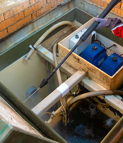 plumber cleans a septic tank using car wash high pressure