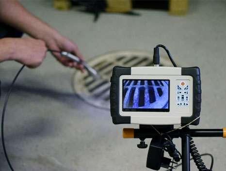 A device shows the front of a sewer gate from the perspective of the camera lens being fed into the system.