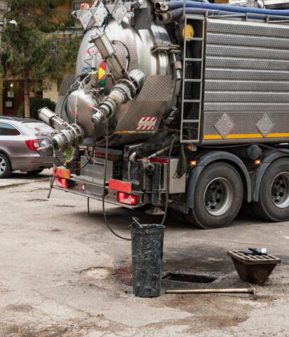 A hy vac truck pumps sludge from pipes.