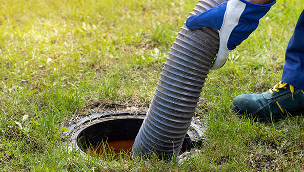 man pumping out house septic tank. drain and sewage cleaning service