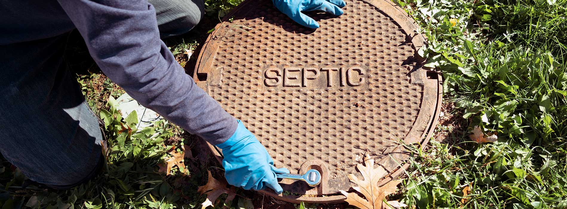 A working plumber opening septic system tank. Copy space for text.