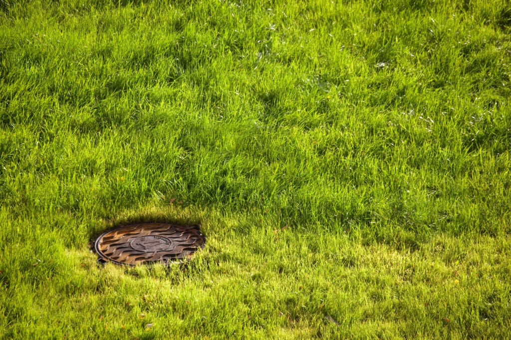 A field with a manhole cover set into the surface.