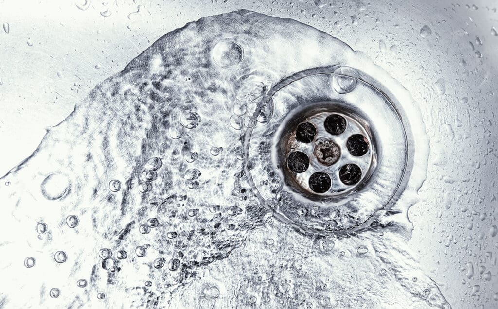 Water flowing down an open sink drain.