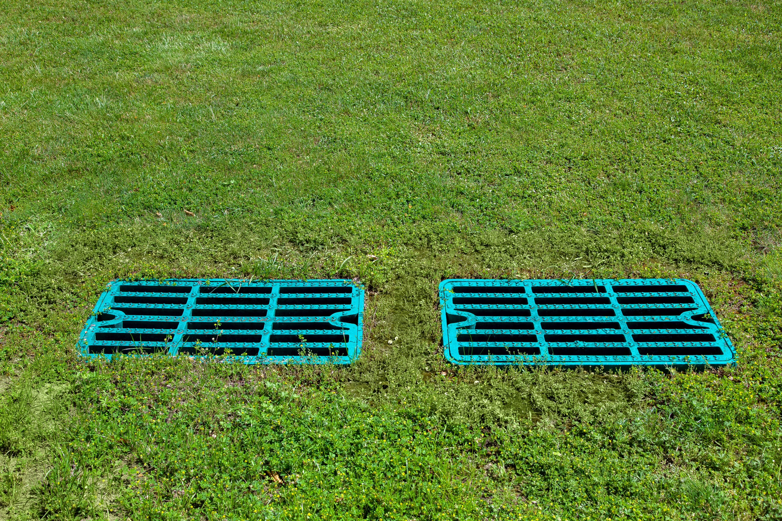 A drain field with two drainage grates set into its surface.