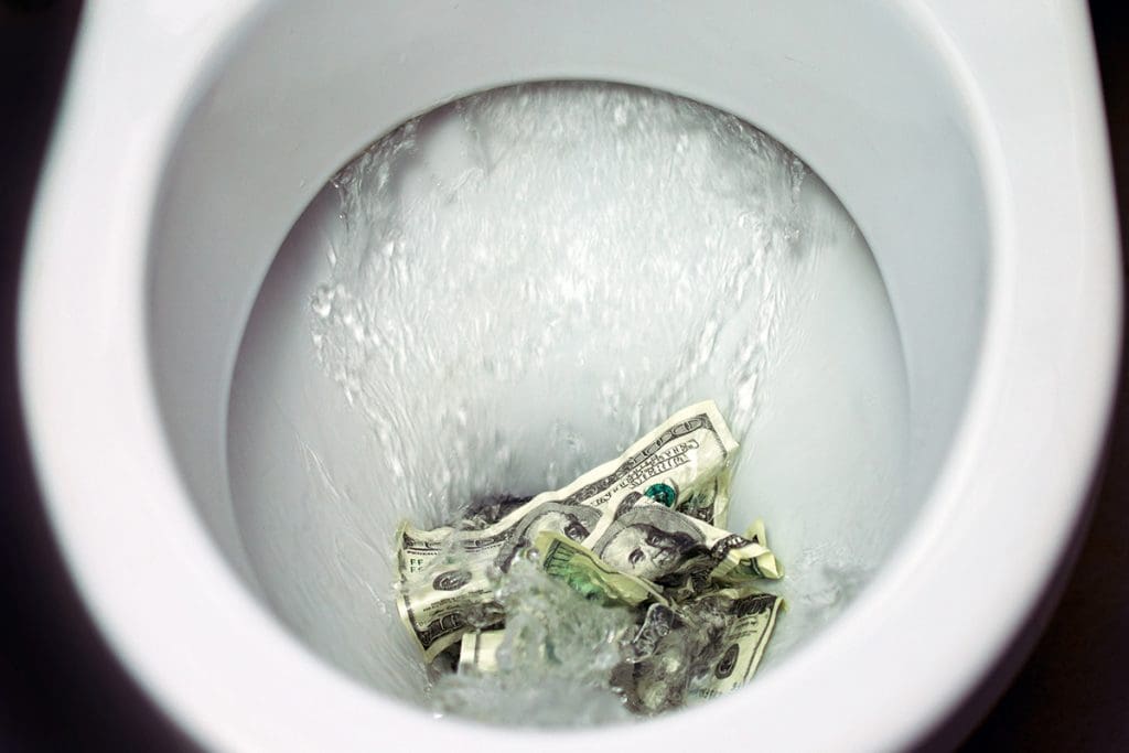 Hundred dollar bills being flushed in the toilet.