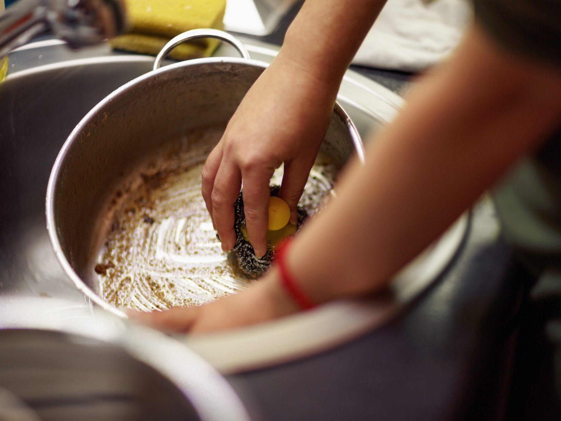 A person cleaning dirty dishes by hand