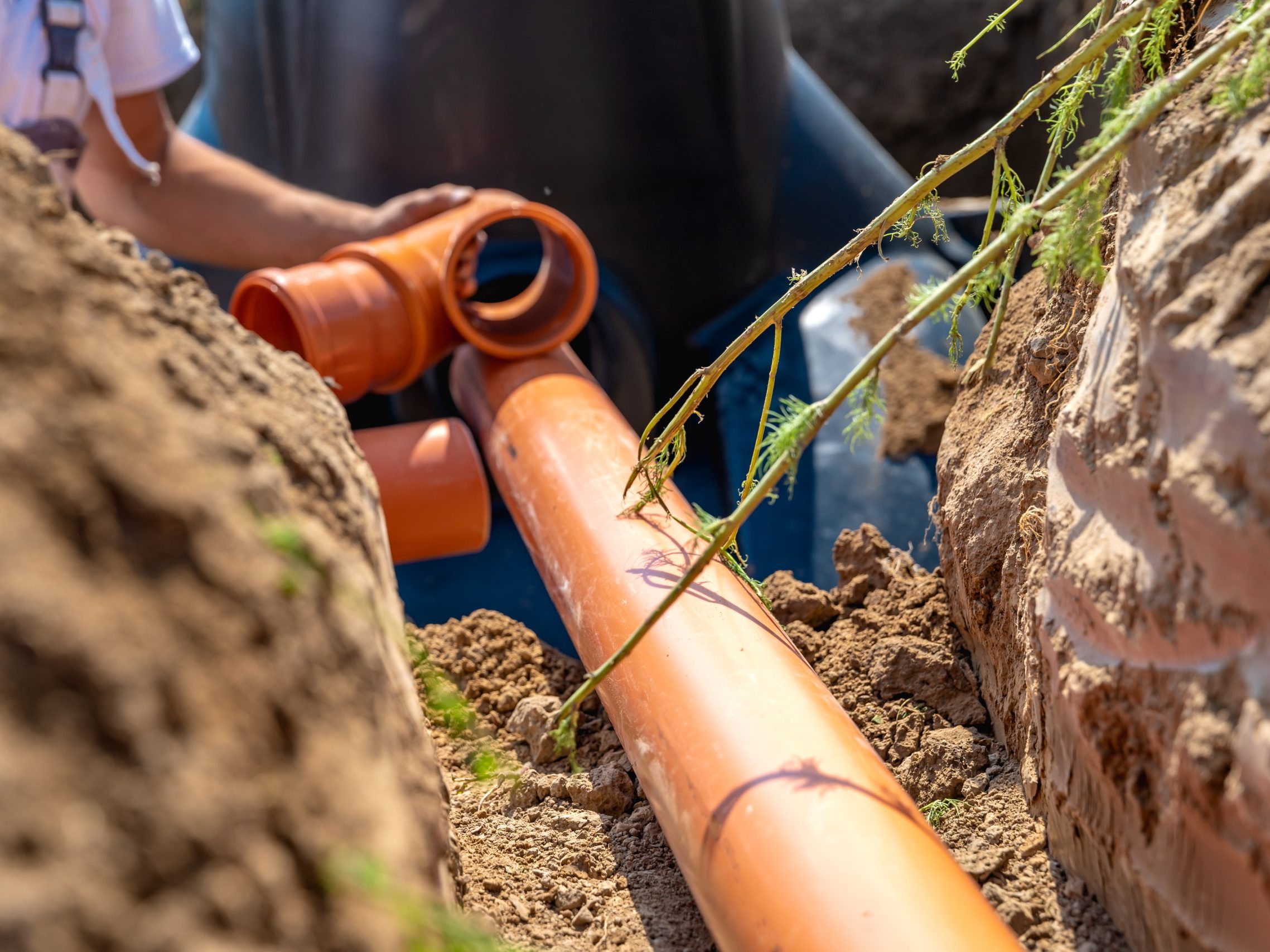 Orange pipes are being dug up out of a yard