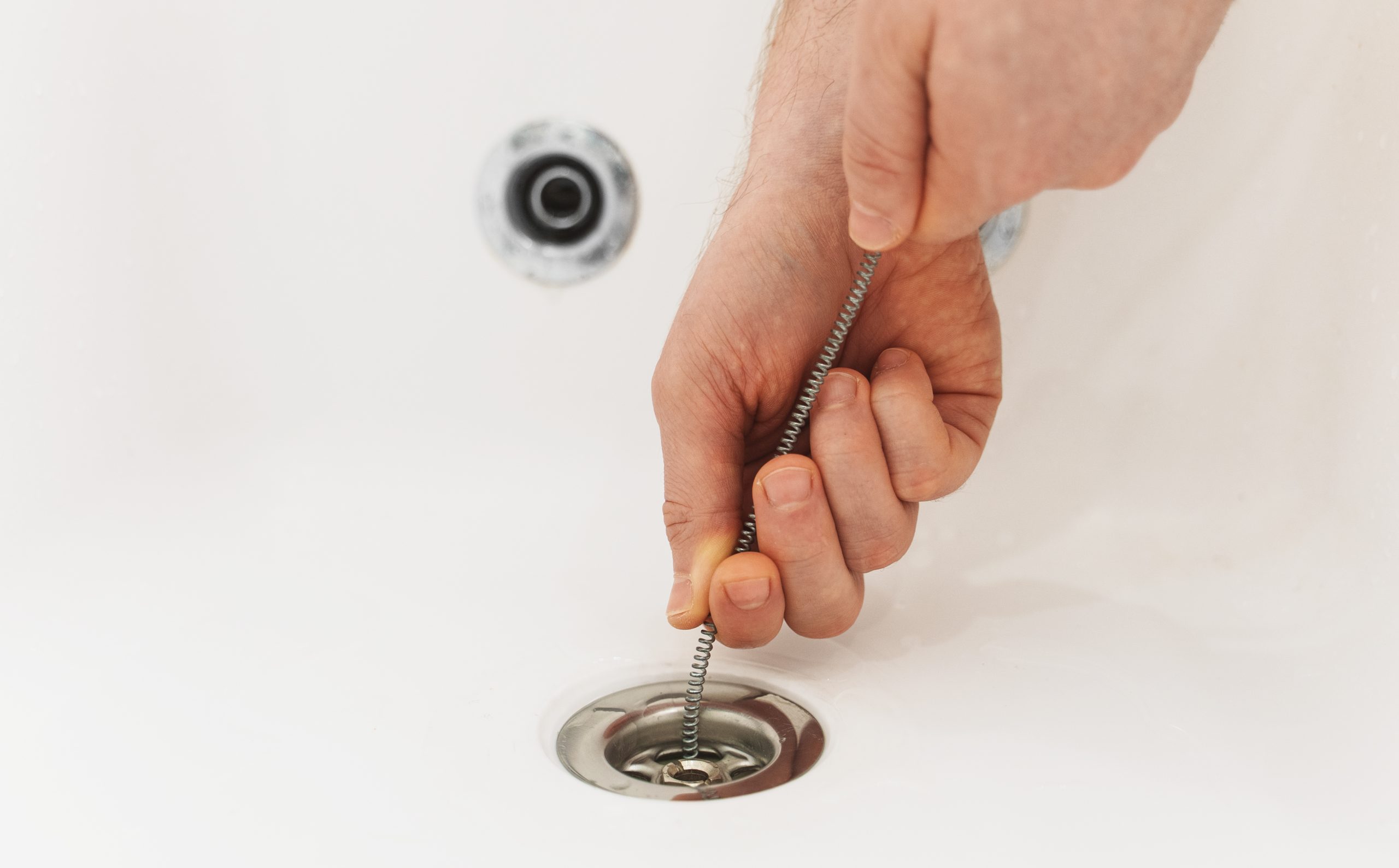 a person cleaning out a drain
