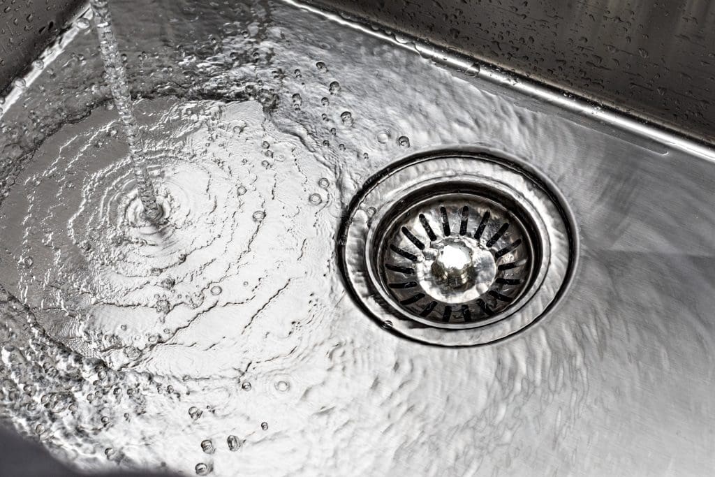 A drain in a silver sink
