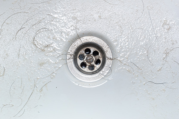 hair and soap scum around a drain