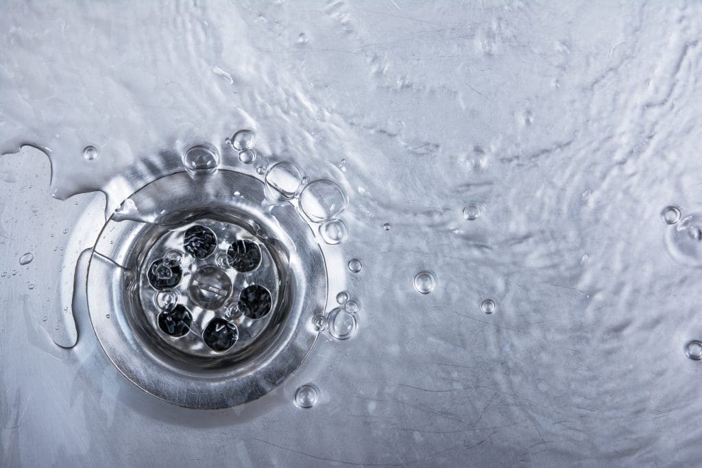 a silver drain with water going down it