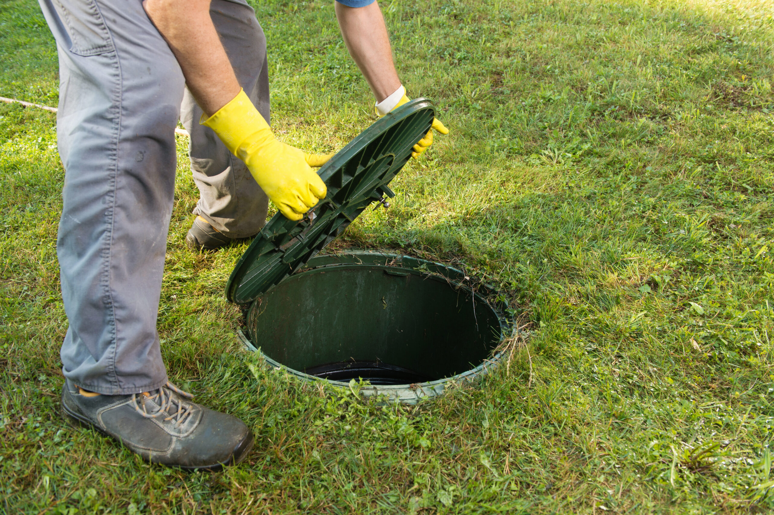 A man putting a lid on a septic system.