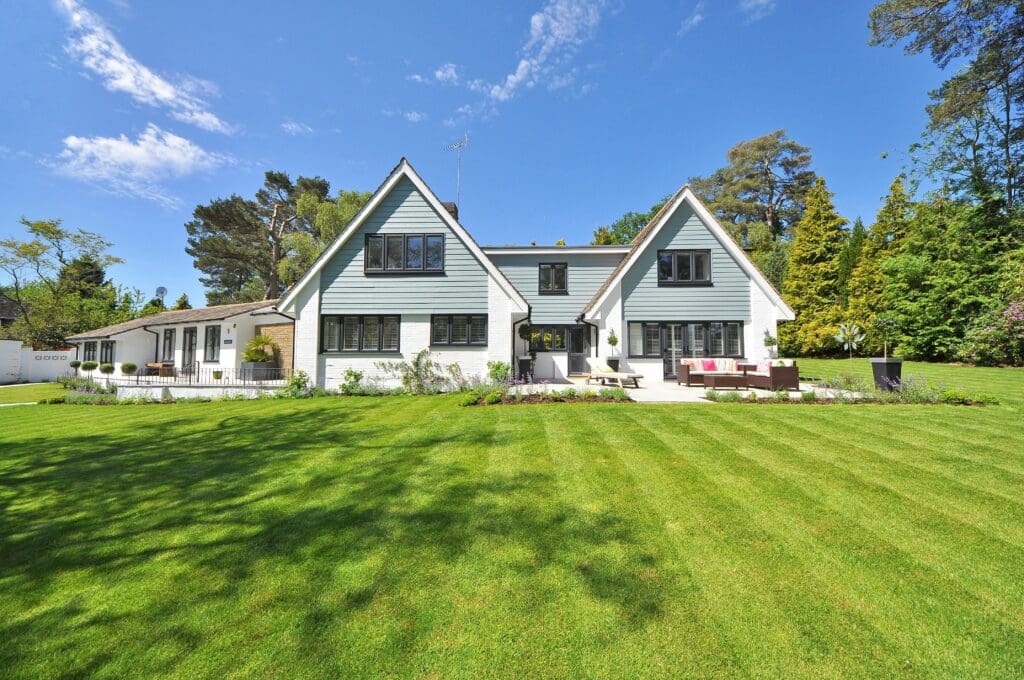 Spacious home with a well-maintained lawn on a sunny day in a residential neighborhood.
