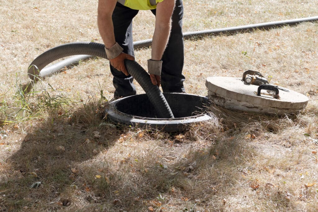A worker pumping a septic tank.