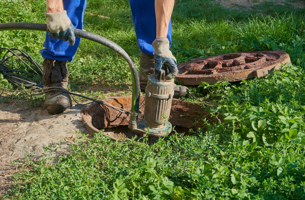 A person pumping a residential septic tank.