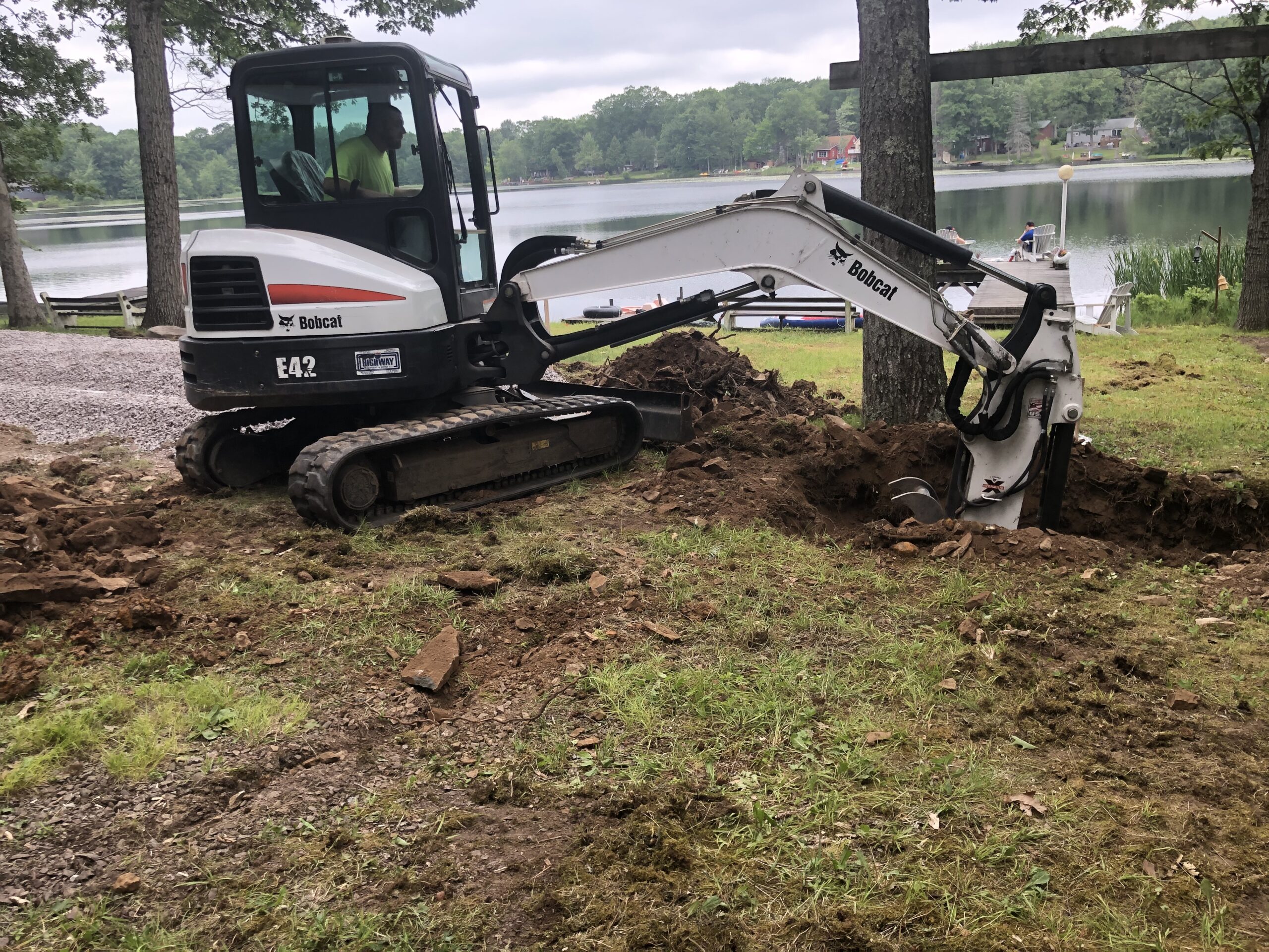 An excavator digging into the ground for a septic tank.